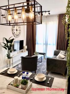 a living room with a chandelier and a living room with a table at Izz'man Homestay Level 33 Troika Kota Bharu in Kota Bharu