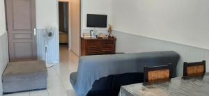 a room with a bed and a tv and a table at Les Anones in Saint-Gilles-les-Bains