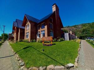 un gran edificio de ladrillo con un cartel delante en Hosteria Las Walkirias en San Martín de los Andes