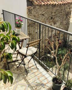 a table and chair on a balcony with plants at Su Zampillu Boutique Rooms Teulada in Teulada