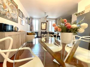 une salle à manger avec une table en verre et des chaises blanches dans l'établissement City Centre Life Apartment Verona, à Vérone