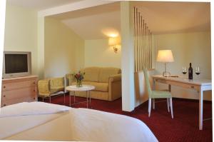 ein Hotelzimmer mit einem Bett, einem Sofa und einem Schreibtisch in der Unterkunft Hotel-Gasthof Beim Böckhiasl in Neukirchen an der Vöckla