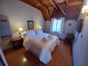 a bedroom with a white bed with two towels on it at Hosteria Las Walkirias in San Martín de los Andes