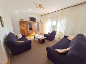 - un salon avec des canapés bleus et une table dans l'établissement Apartments Vesna, à Novi Vinodolski
