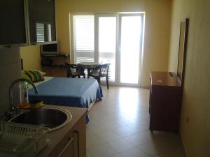 eine Küche mit Spüle und ein Bett in einem Zimmer in der Unterkunft Apartments Teatina in Brodarica