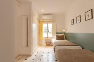 two beds in a room with a window at Villa Ca na Tonina - La Goleta Hotel de Mar & Villas in Port de Pollensa