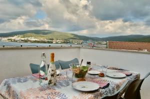 - une table avec des bouteilles de vin et des verres sur le balcon dans l'établissement Fogar das Pupieiriñas, à Corcubión
