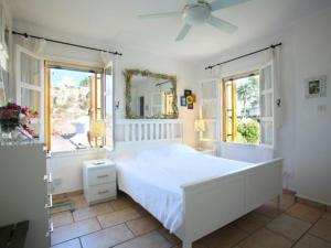 a white bedroom with a large bed and two windows at Profitis Elias Hill Top in Protaras