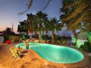 a swimming pool with a table and chairs and trees at Profitis Elias Hill Top in Protaras