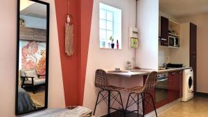 a kitchen with a counter and two bar stools at studio Orange - Parc Astérix - Mer de Sable - Villepinte - Aéroport CDG in Vémars