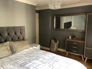 a bedroom with a large bed and a mirror at Stylish 2 bed apartment next to the Norfolk Broads in Coltishall