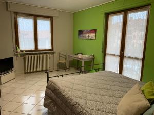 um quarto com paredes verdes, uma cama e uma secretária em I Pini - appartamento em Boves