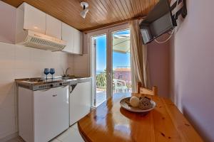 a kitchen with a stove top oven and a window at Anemos Studios & Apartments in Poros