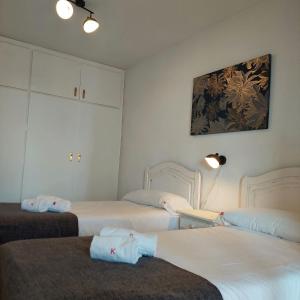 a room with three beds and a painting on the wall at Best View - Welcome Penthouse Apartamentos Karola in Benidorm