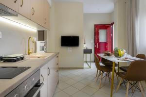 a kitchen with a table and chairs and a red door at Nikola's & Joanna's apartments in Argostoli