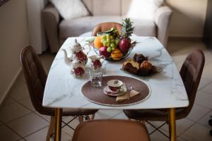a table with a plate of food and a bowl of fruit at Nikola's & Joanna's apartments in Argostoli