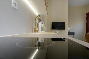 a kitchen counter with a sink and a tv at Nikola's & Joanna's apartments in Argostoli
