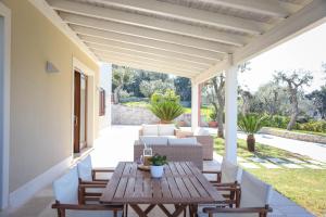 an outdoor patio with a wooden table and chairs at VILLA LAURETO - By Apulia Hospitality in Selva di Fasano