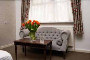 a living room with a couch and a vase of flowers on a table at Hamlet Hotels Maidstone in Maidstone