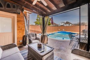 ein Wohnzimmer mit einer Terrasse und einem Pool in der Unterkunft * *ASTOUNDING HOUSE **Perfect for Family and friends , Pool , Hot Tub, & GAME ROOM in Allen