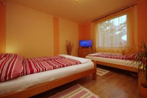dwa łóżka w pokoju z oknem w obiekcie Bodza apartman w mieście Gyula