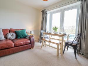 a living room with a red couch and a table at Mawnog Fach in Bala