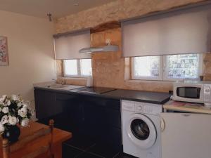 a kitchen with a washing machine and a microwave at Gite Eynardou in Naussannes