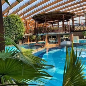 a large swimming pool in a building with a roof at Tatralandia Chatky in Liptovský Mikuláš