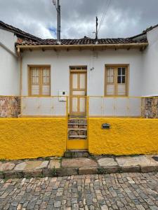 Cantinho em Ouro Preto في أورو بريتو: بيت اصفر وبيضاء مع باب اصفر