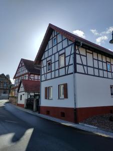 un edificio blanco y negro al lado de una calle en Ferienwohnung am Krayenberg en Kieselbach