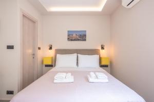 a bedroom with a large white bed with two white towels at ✰Bright, renovated, spacious and cosy studio✰ in Athens