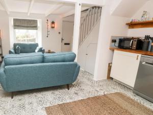 a living room with a blue couch and a kitchen at 3 Peters Terrace in Truro