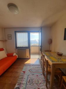 sala de estar con sofá rojo y mesa en Apartment San Giacomo - Brentonico, en Brentonico