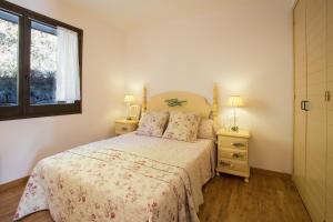 a bedroom with a bed with two night stands and a window at Ca la Manet in Queralbs