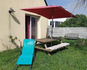 tavolo da picnic con ombrellone rosso e sedia blu di Idéal Famille à 700m plage - Paddle et vélo inclus a Loctudy