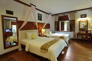 ein Hotelzimmer mit zwei Betten und einem Spiegel in der Unterkunft Sokhalay Angkor Villa Resort in Siem Reap + 39 Fotos