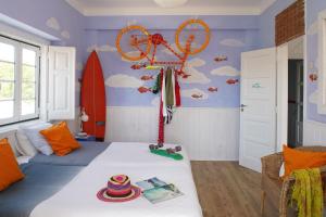 Chill in Ericeira Surf House في إيريسييرا: غرفة نوم مع سرير ودراجة على الحائط