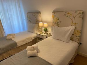 - 2 lits dans une petite chambre avec une lampe sur une table dans l'établissement Cosy Avenida Apartment, à Faro