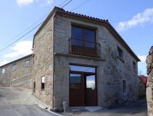 una vecchia casa in pietra con balcone laterale di Casa Veiga 1 a Pontevedra