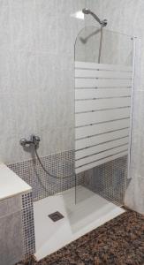 a shower with a glass door in a bathroom at Mesón Kubano B&B in Sant Mateu