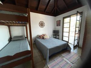 a bedroom with two bunk beds and a window at Suites e Casa_Pauba in São Sebastião