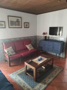 a living room with a red couch and a coffee table at Fazenda do Marante in Tomar