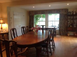 a dining room with a wooden table and chairs at The Martins B&B in Chelsworth