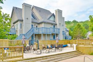Casa grande con terraza con sillas y mesas. en Condo 211 At North Creek Resort, en Blue Mountains