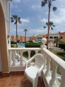 - un balcon blanc avec une chaise et une piscine dans l'établissement 059 Bungalow Torrelamata, à Torrevieja