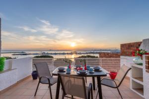 a table and chairs on a balcony with the sunset at R30-CASA junto al MAR, PRECIOSAS VISTAS in Roses