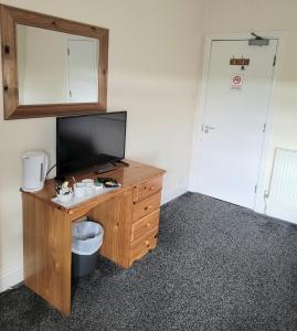 a room with a desk with a television on it at The Glazebury bar and restaurant with accommodation in Glazebury