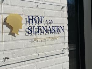 un panneau sur le côté d'un mur de briques blanches dans l'établissement Hof van Slenaken - Hotel & Apartments, à Slenaken
