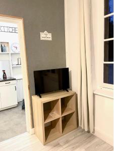 uma televisão de ecrã plano numa bancada numa sala de estar em Appartement studio avec terrasse et jardin privés em Boulogne-sur-Mer