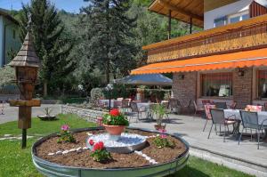 un patio con un letto a fiori nel cortile di Hotel & Residence Sylvanerhof a Chiusa